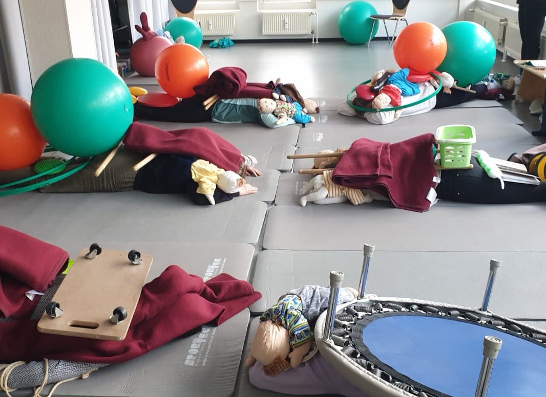 Kursraum mit Matten, Babys und Spielzeug
