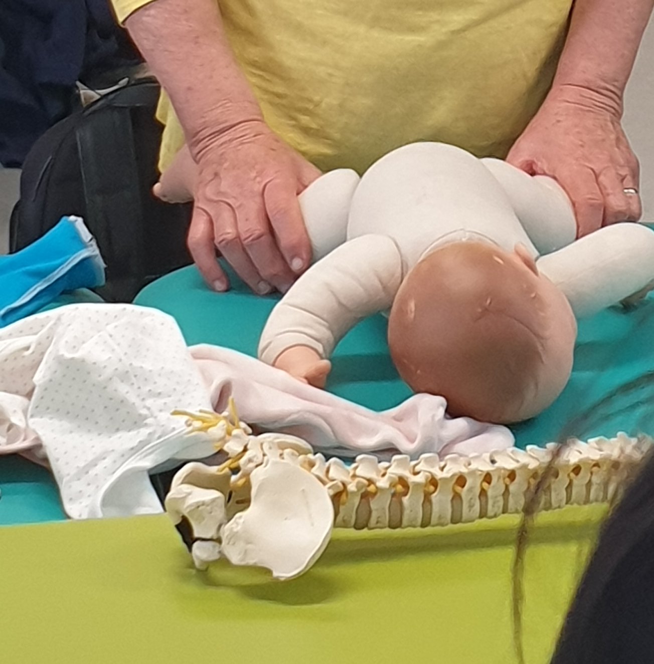Babypuppe und Wirbelsäulenmodell in der KISS-Ausbildung